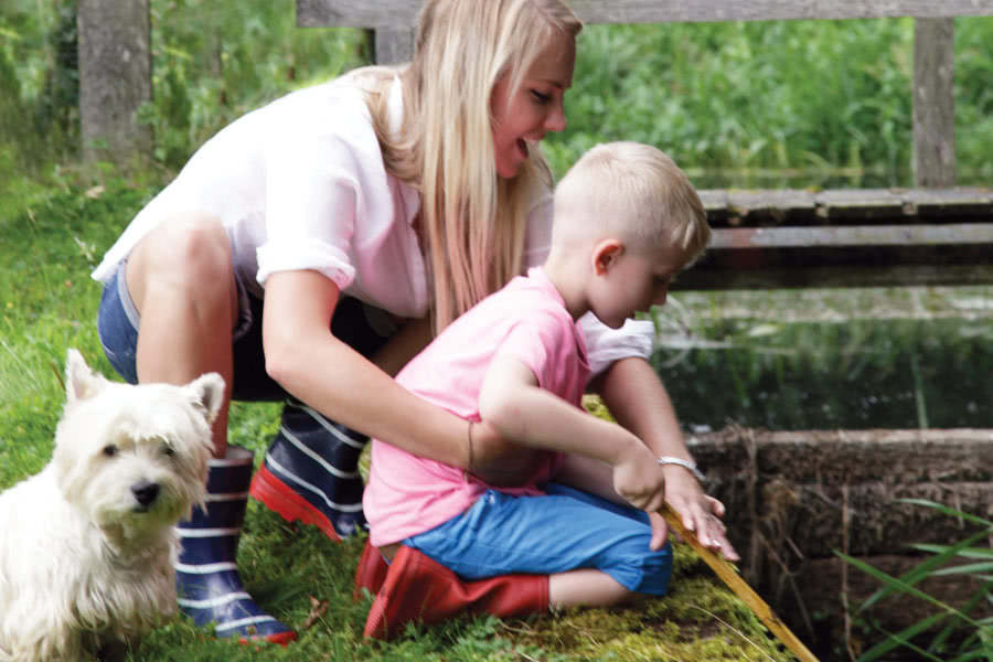 Mum, little boy and a dog enjoying the outdoors pond dipping